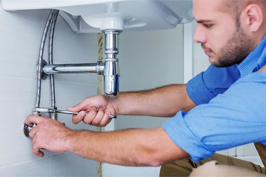 Plumber working under sink