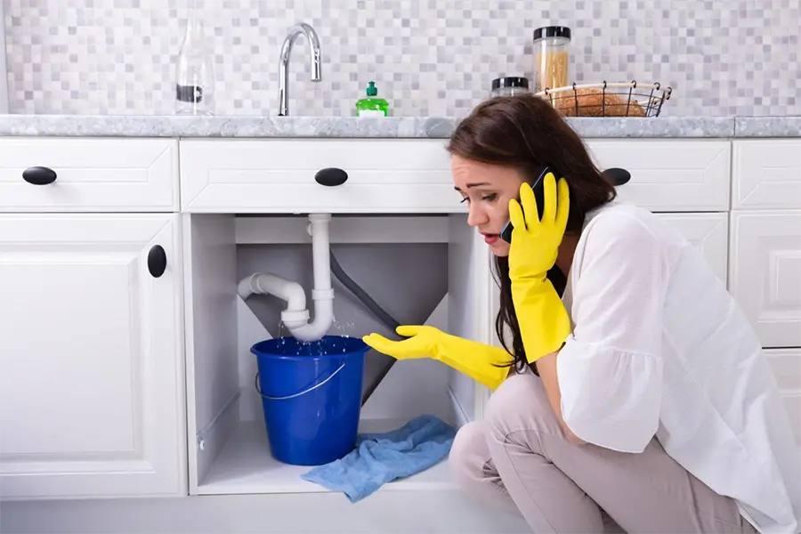 Woman contacting an emergency plumber