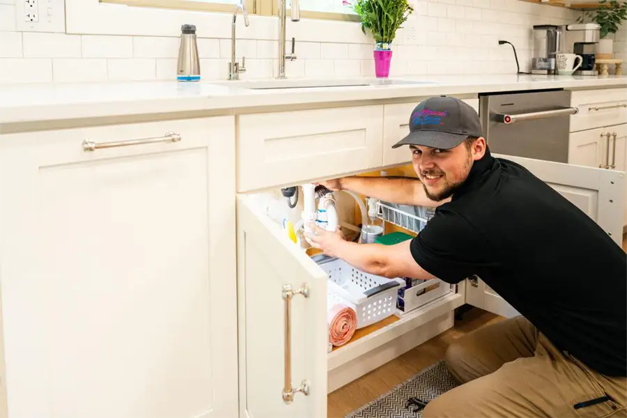 Plumber working under kitchen sink